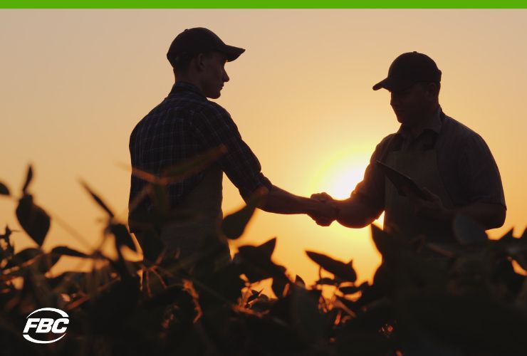 Farmers in corn field shaking hands