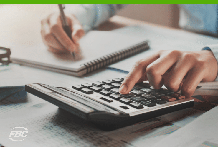 Working at desk with calculator - cash flow