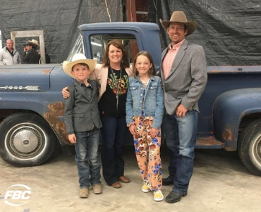 a farm family stands in front of a truck