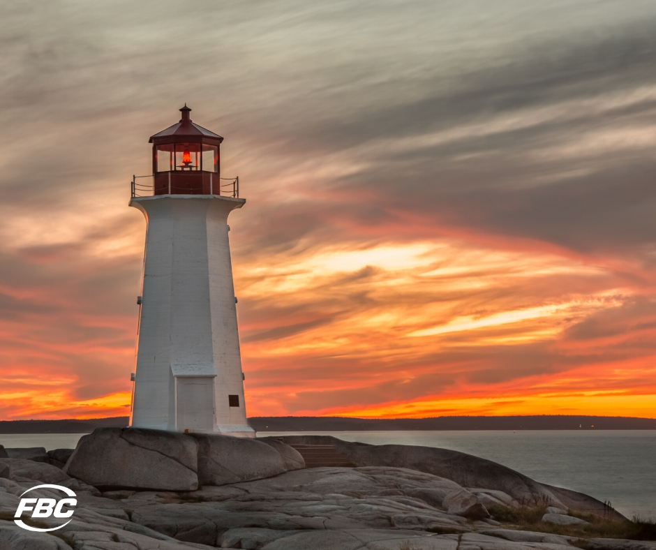 A lighthouse in nova scotia with a sunset behind it